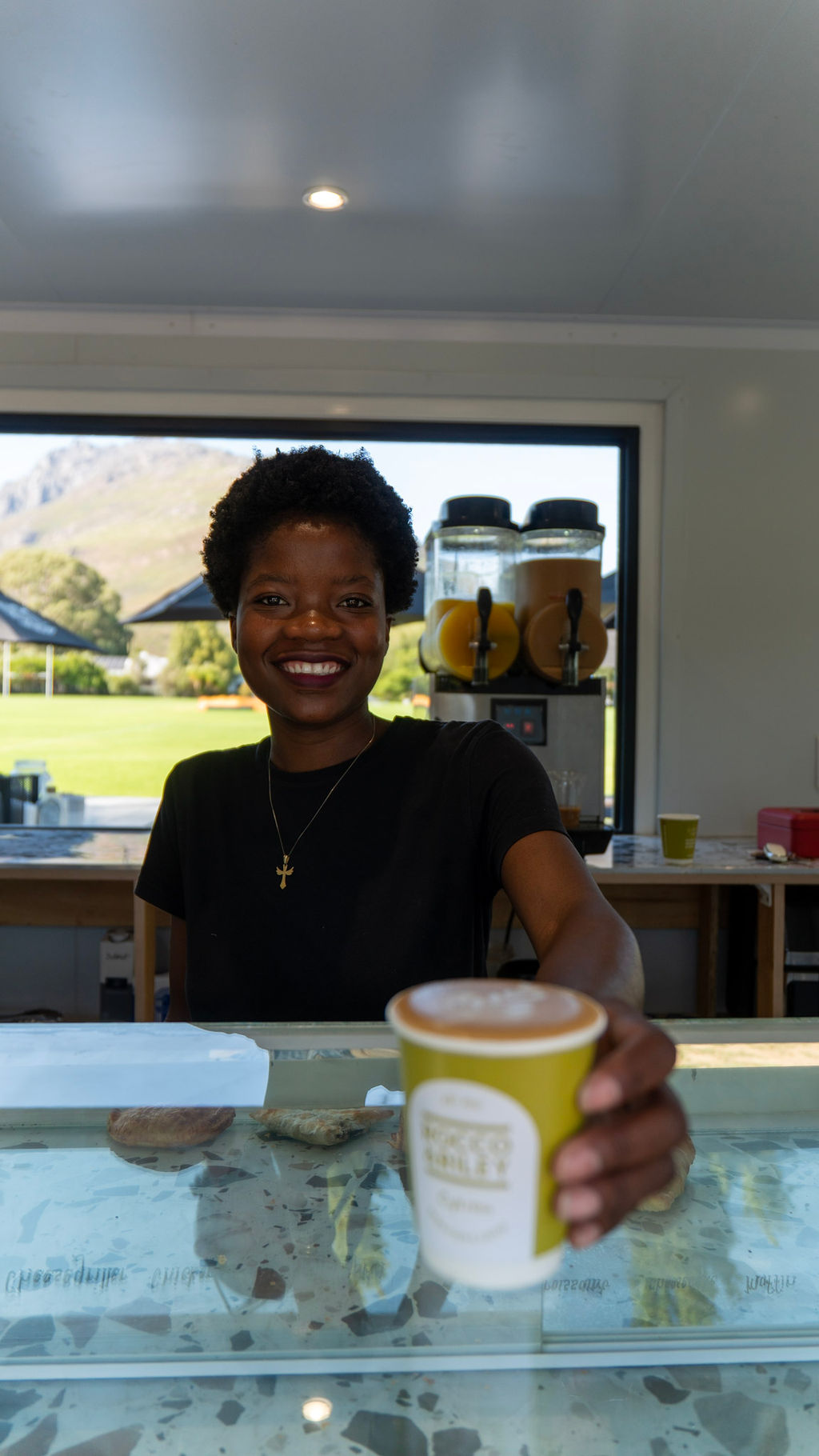 Barista serving a fresh coffee at Die Neutekraker
