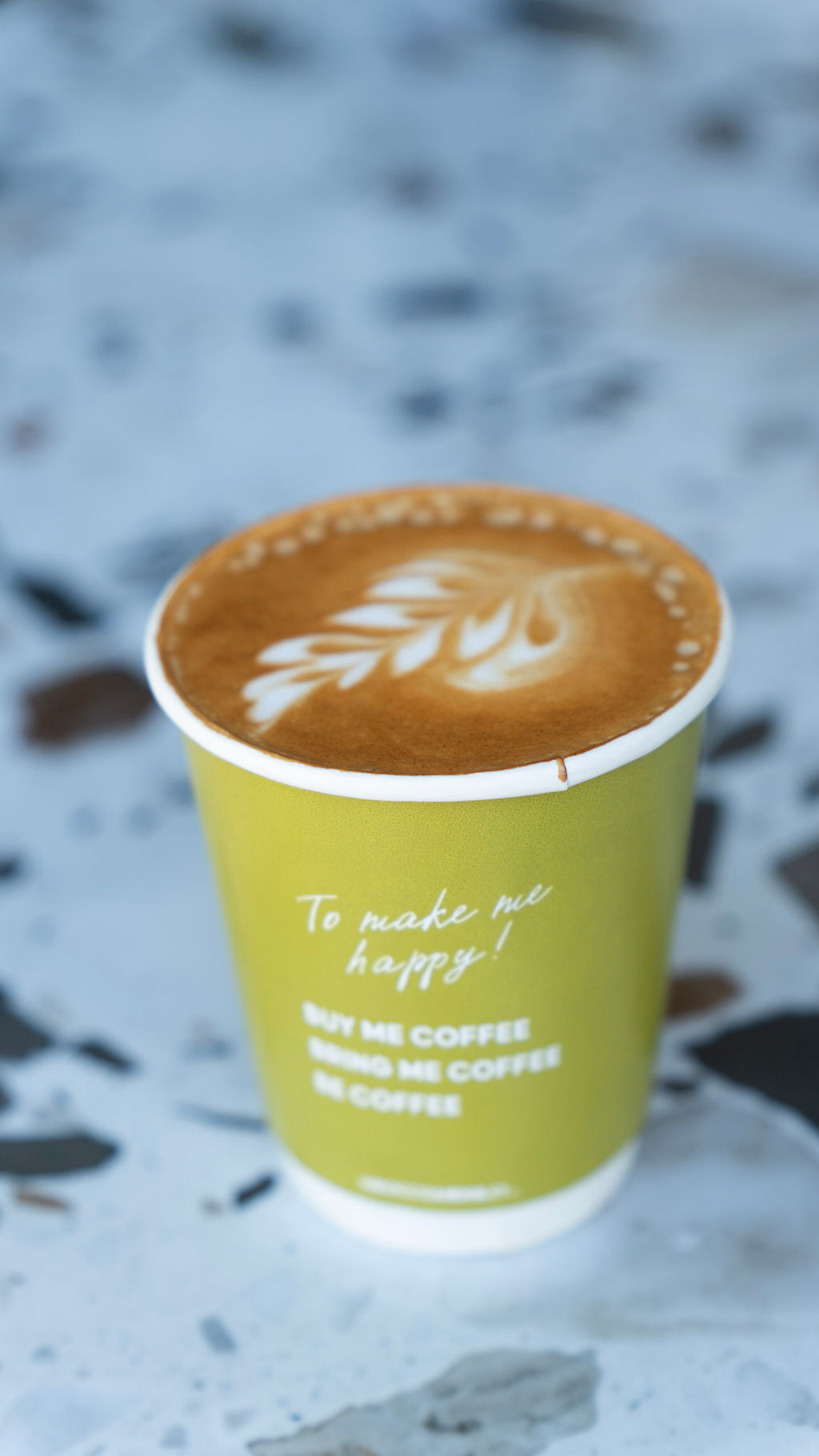 Rocco & Riley latte with leaf art in olive branded cup